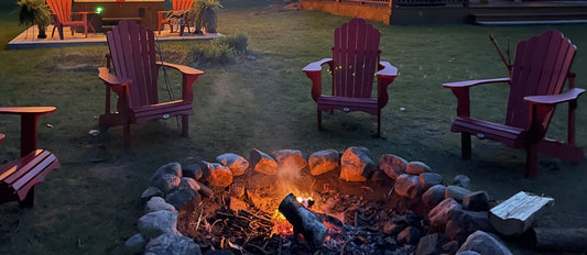 
Garden fire pit burning at dusk with wooden chairs around it, and a hot tub on its own platform well away from the fire in th