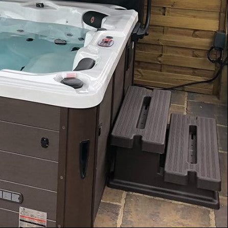 
Hot tub with steps leading up to it on a patio